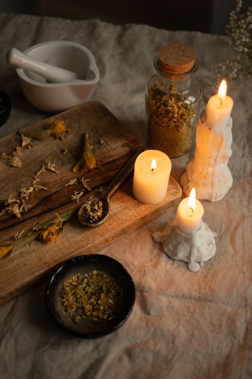 Free Warm ambiance with candles, dried herbs, and mortar on rustic surface. Stock Photo