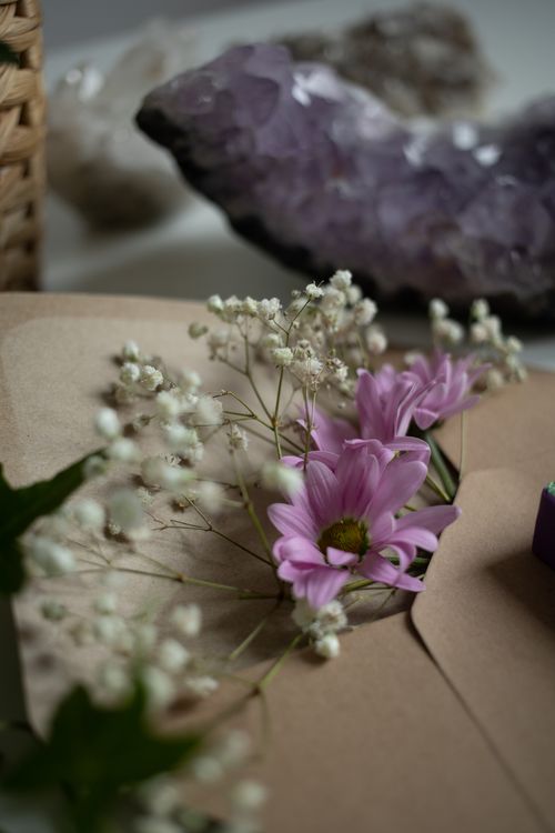 Free A delicate arrangement of pink flowers and white buds with amethyst crystal. Stock Photo