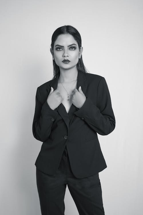 A woman in a suit posing for a black and white photo
