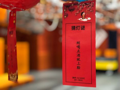A vibrant red tag with Chinese text hanging in a festive setting, perfect for cultural celebrations.