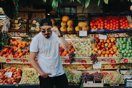 Homem Em Pé Ao Lado De Frutas Sortidas