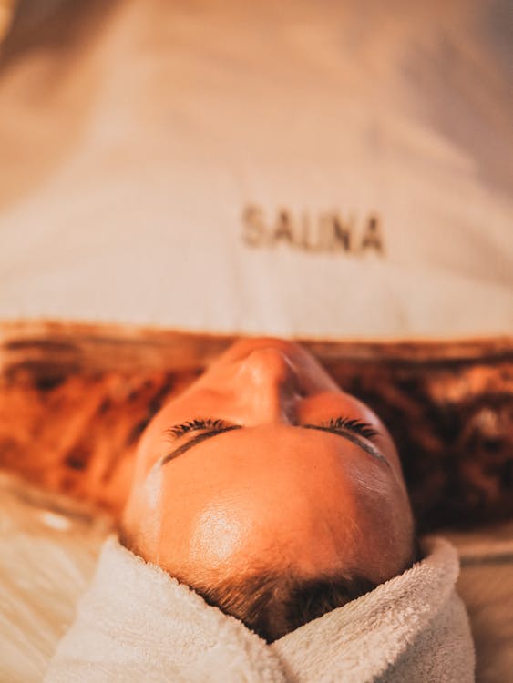 Free A woman laying down in a spa with a towel on her head Stock Photo