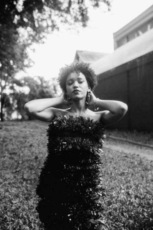 A woman in a dress poses for a black and white photo