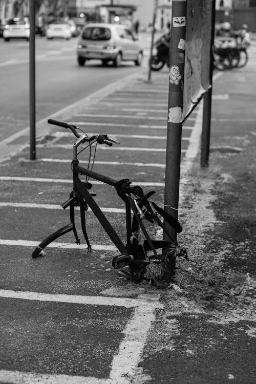 A black and white photo of a bicycle leaning against a pole