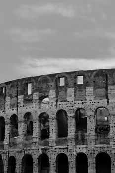 Black and white photo of the iconic Colosseum in Rome, showcasing ancient architecture.