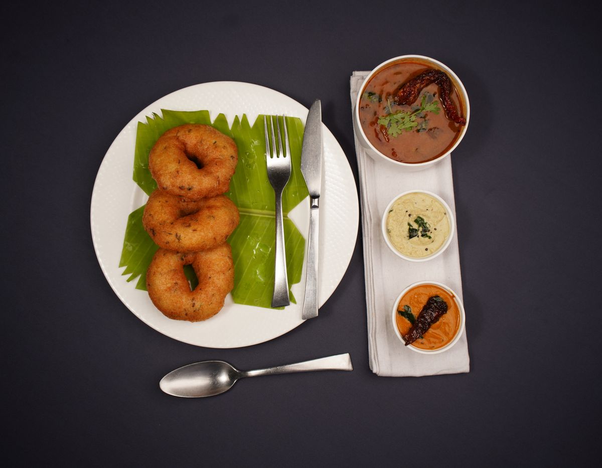 Medu vadai with chutneys on a dark background