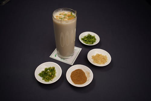 A glass of milk with various spices and herbs