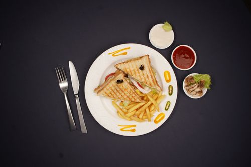 Free Top view of a sandwich with fries, mayonnaise, ketchup, and sauce on a black background. Stock Photo