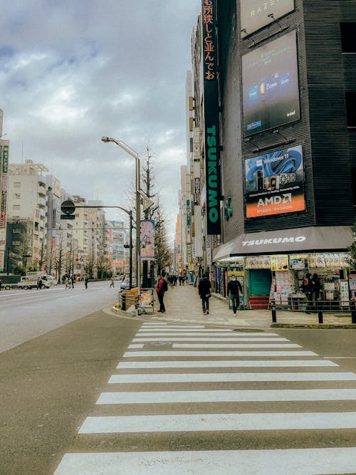 A city street with a crosswalk and a sign that says, 'the best place to eat in tokyo'