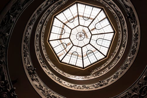 A circular spiral staircase with a glass dome