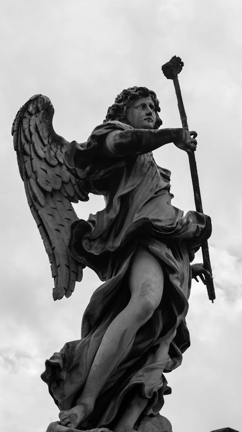 A black and white photo of an angel holding a sword