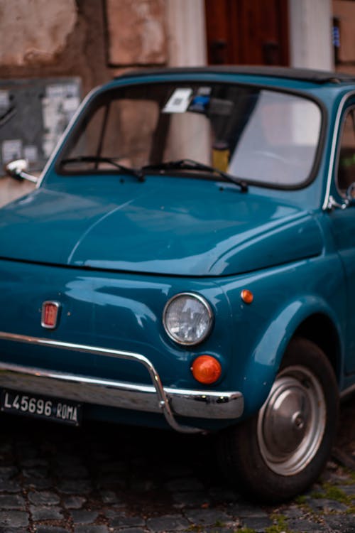 A blue fiat 500 parked on the street