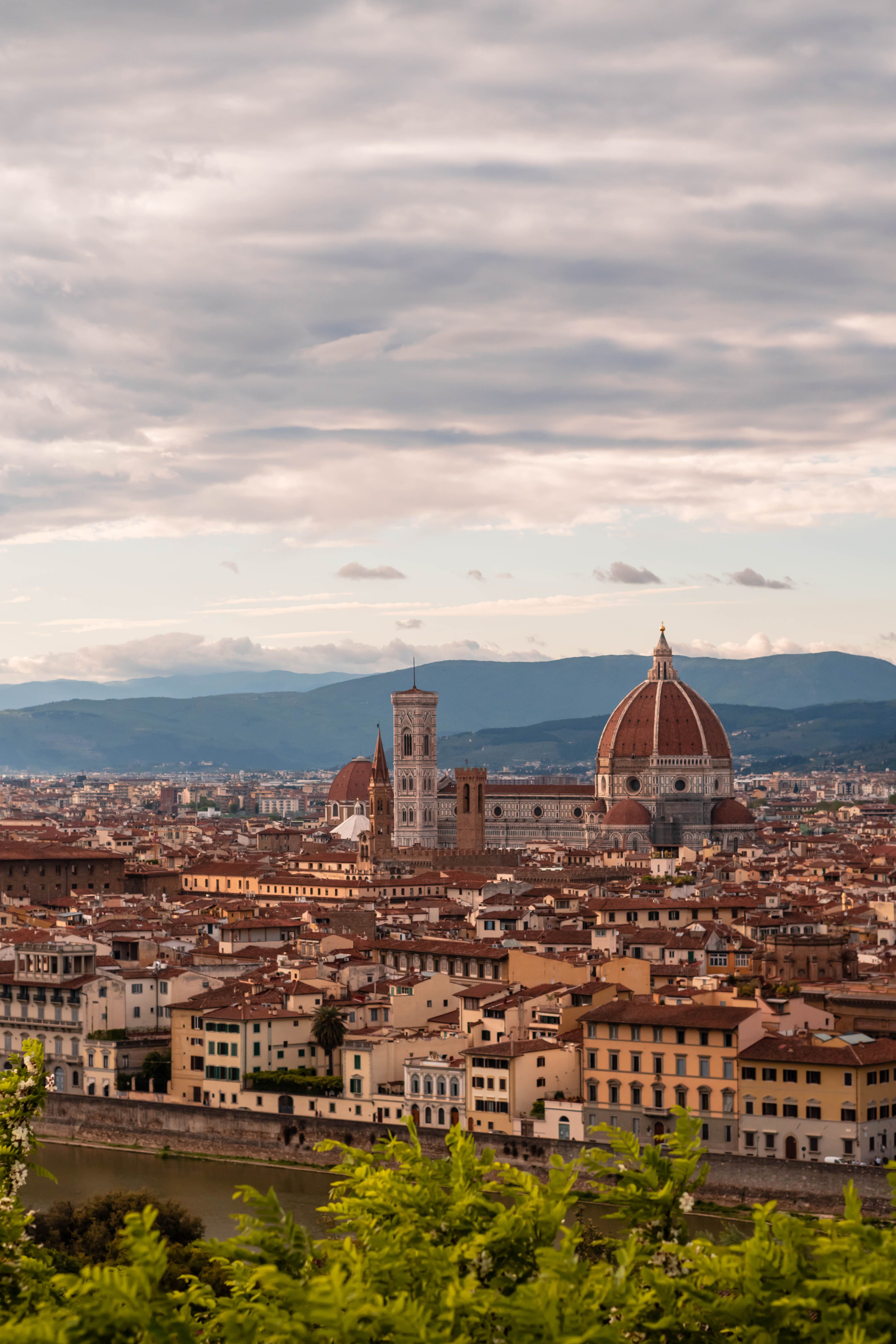 Scenic view of Florence's historic skyline featuring the iconic cathedral and dome under cloudy skies.