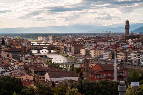 Free A breathtaking view of Florence, Italy featuring the iconic Ponte Vecchio and surrounding architecture. Stock Photo