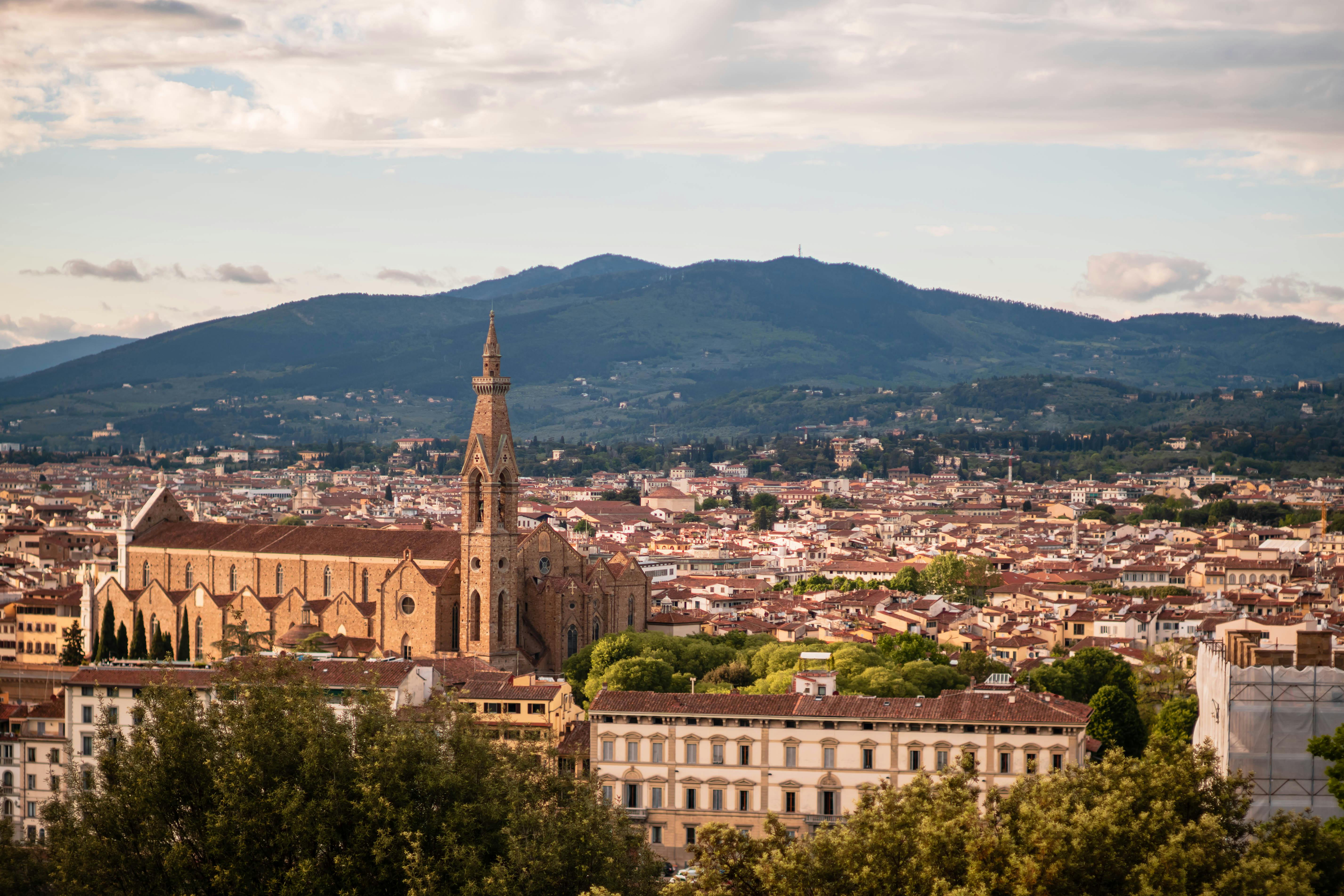 A picturesque view of the Basilica of Santa Croce against the backdrop of Florentine hills.