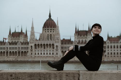 A woman sitting on a ledge in front of a building