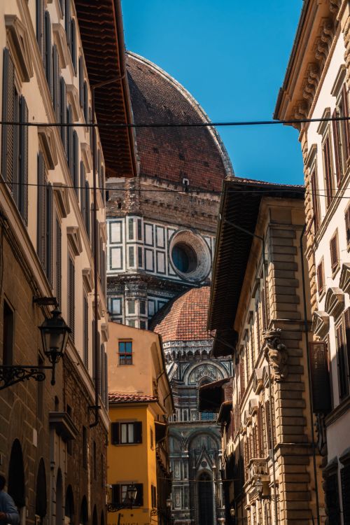 Free Charming view of Florence Cathedral's dome from a narrow street in Florence, Italy. Stock Photo