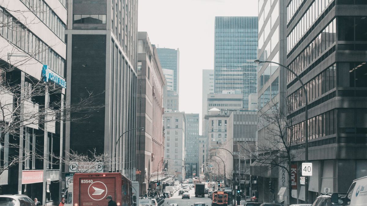 Lively street scene in downtown Montreal, showcasing urban architecture and bustling traffic.