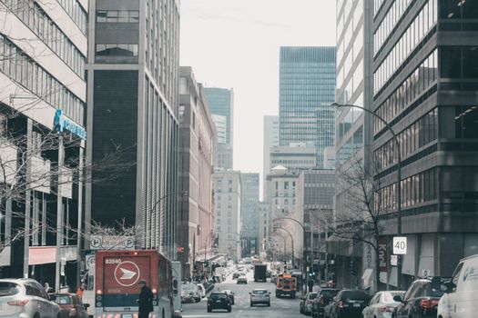 Lively street scene in downtown Montreal, showcasing urban architecture and bustling traffic.