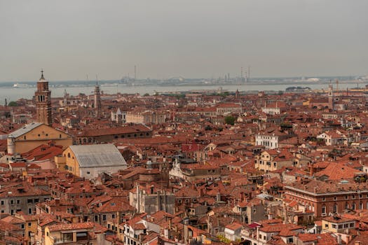 A sweeping aerial view of Venice, Italy, showcasing its iconic red rooftops and tranquil urban landscape.