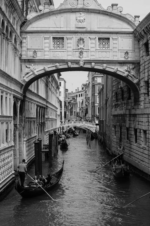 A black and white photo of a bridge over water