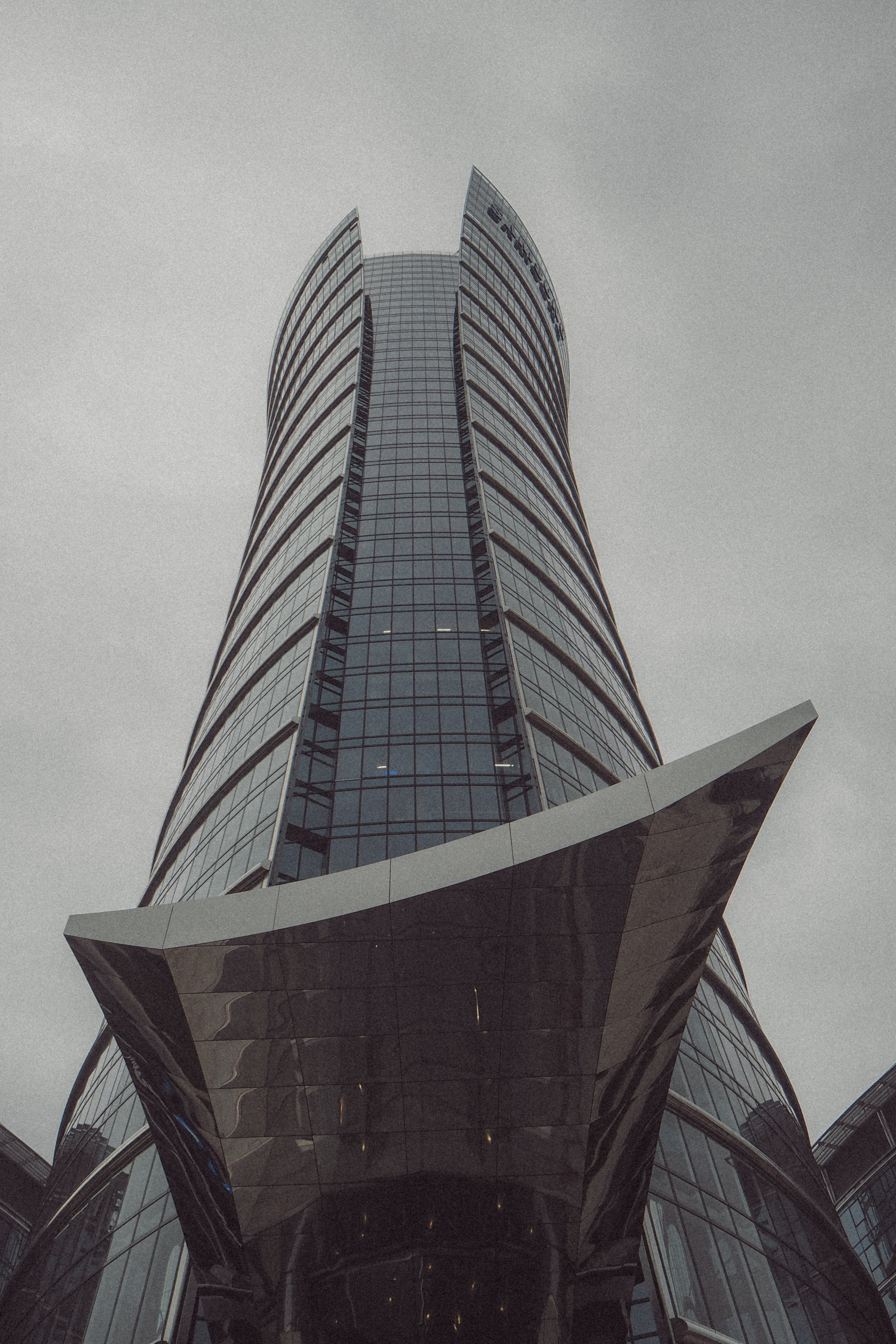 A modern skyscraper with a unique design viewed from below in Warsaw, Poland.