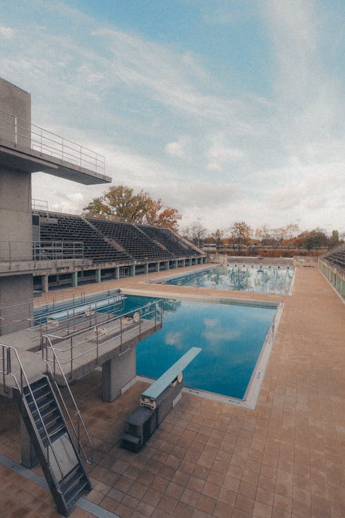 A swimming pool with a diving board and stairs