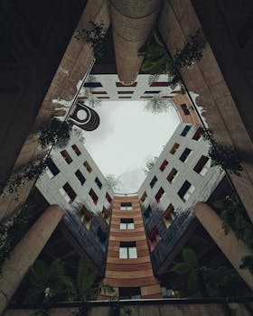 A striking view of modern architecture with plants in an urban courtyard setting.