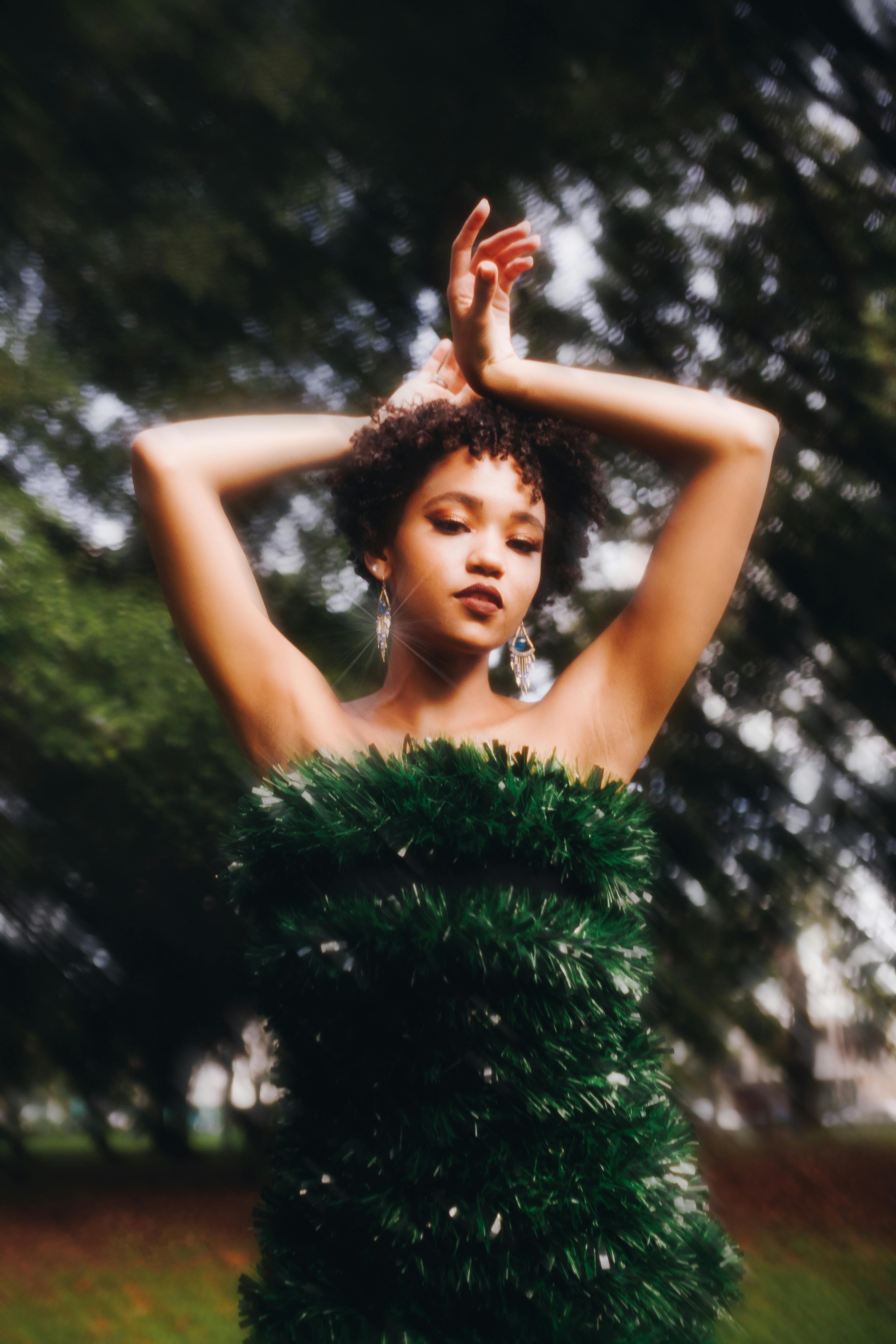 Free Stylish woman poses outdoors in a green dress, embodying elegance and nature. Stock Photo