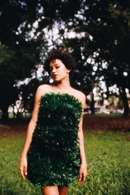 A woman in a green dress standing in the grass