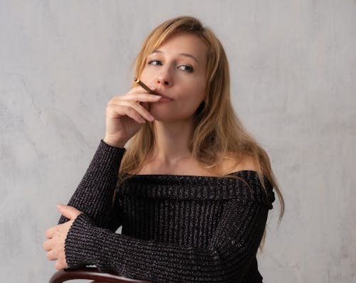 A woman smoking a cigarette in a black sweater