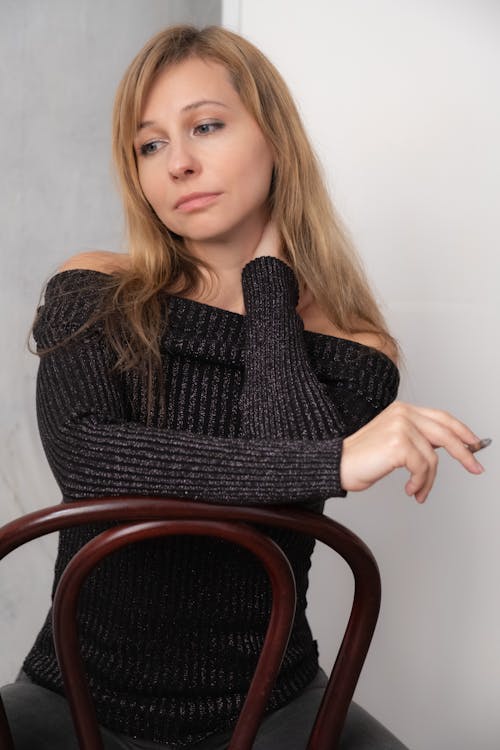 A woman in a black sweater sitting on a chair