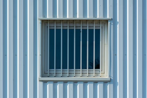 Barred Window of a Building Made of Corrugated Sheet Metal
