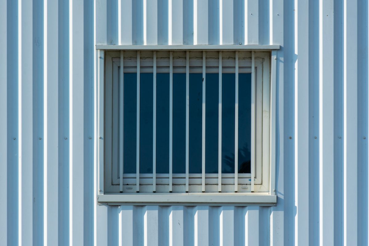 Fenêtre protégée par une grille métallique sur une façade