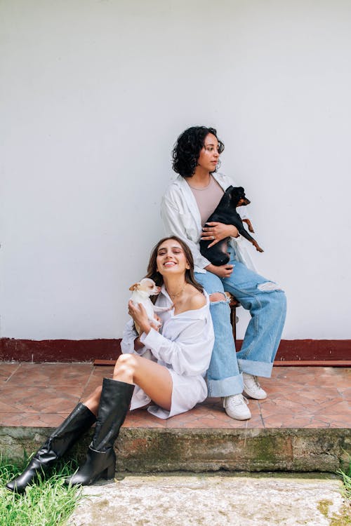 Two women sitting on the steps with their dog