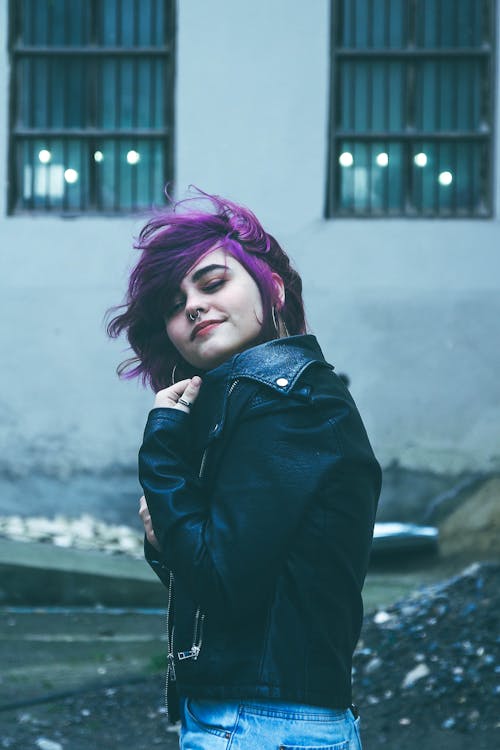 A woman with purple hair and a black jacket