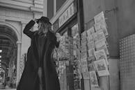 一位穿着黑色外套、戴着黑色帽子的时尚女性在城市街头的户外摆姿势