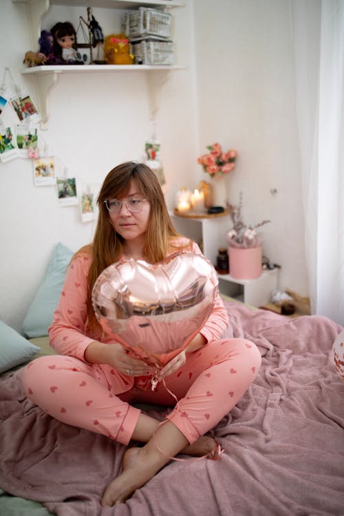 Woman Sitting in Bed with Balloon
