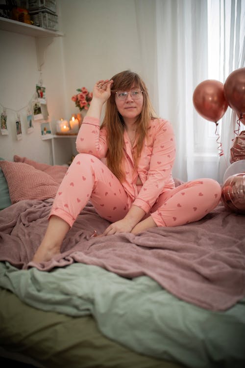 Woman in Pajamas with Hearts on Bed