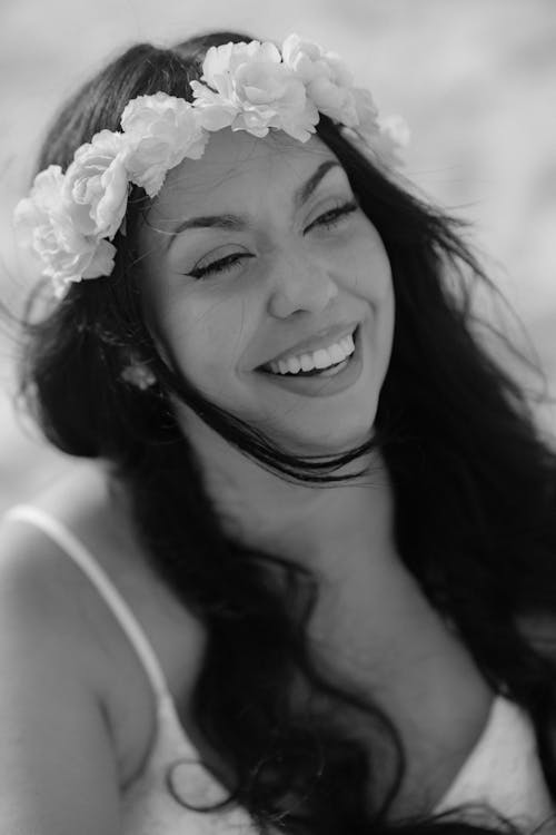 A woman smiles while wearing a flower crown