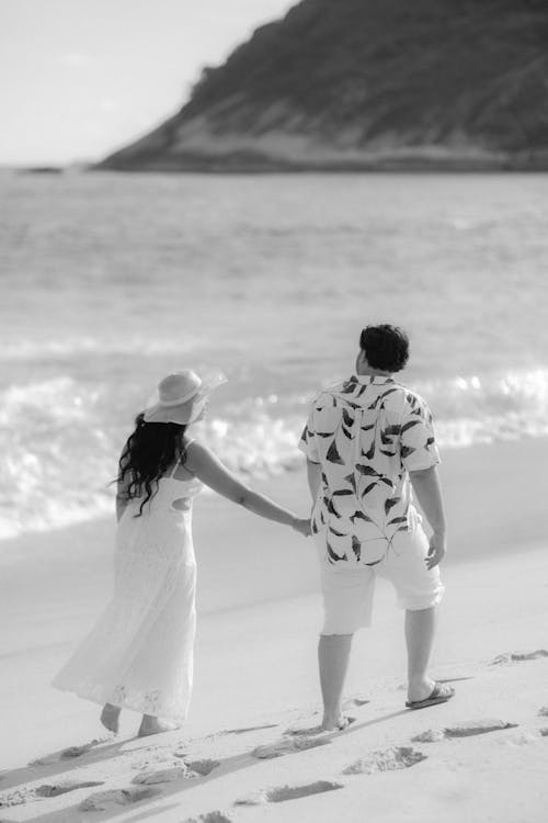 A man and woman walking on the beach