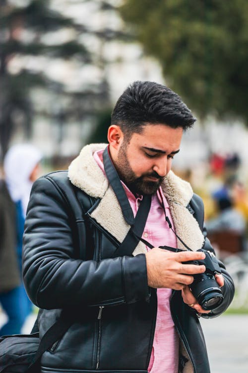 A man in a leather jacket taking a picture