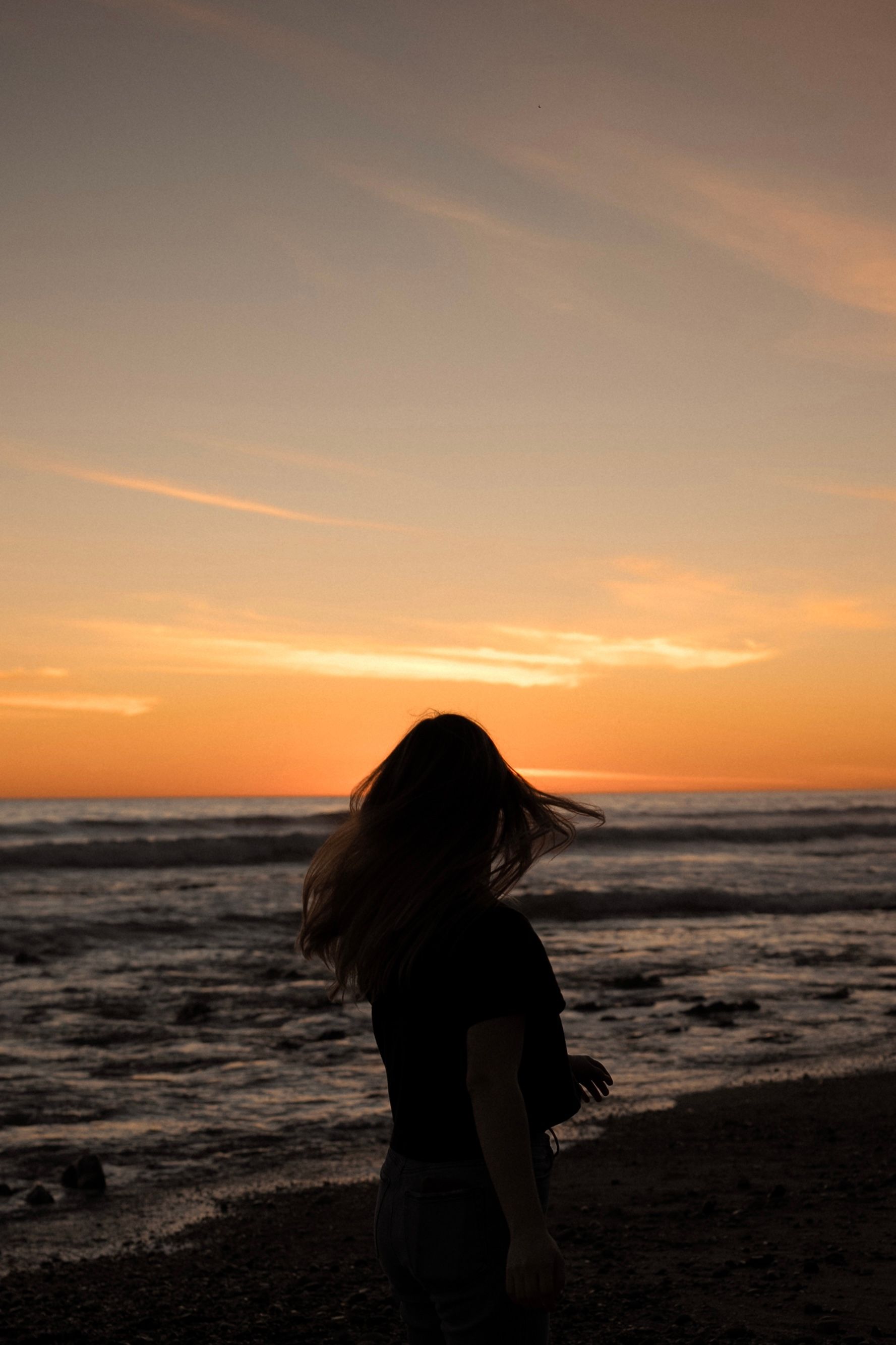 Woman Standing on Sea Shore at Sunset · Free Stock Photo