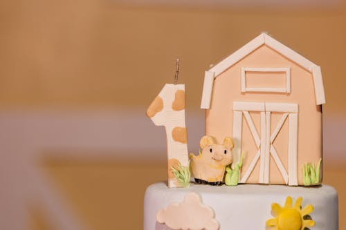 A cake with a cow and barn on top