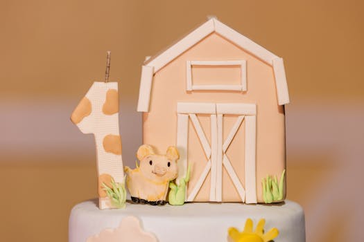 Cute first birthday cake topper with barn and piglet decoration in pastel colors.