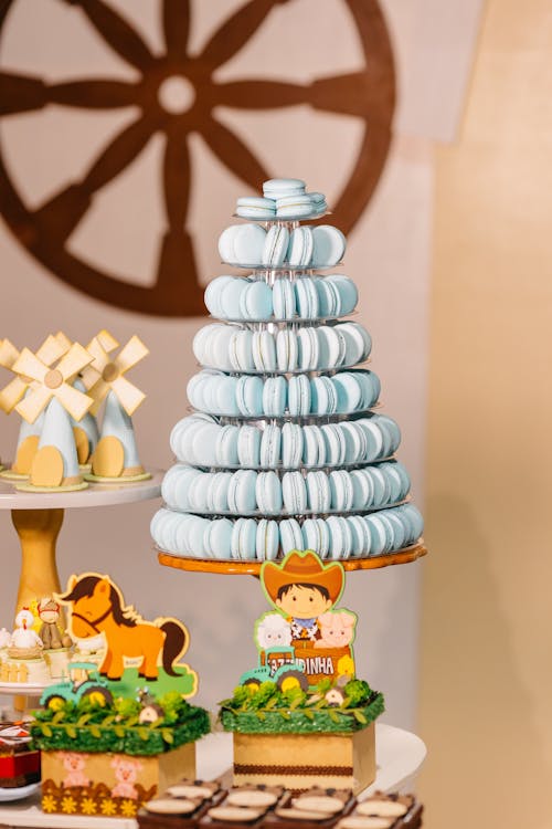 A table with a blue and white cake and macarons