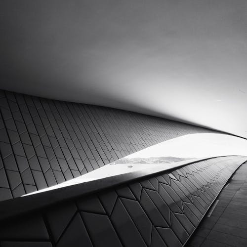 A black and white photo of a curved walkway