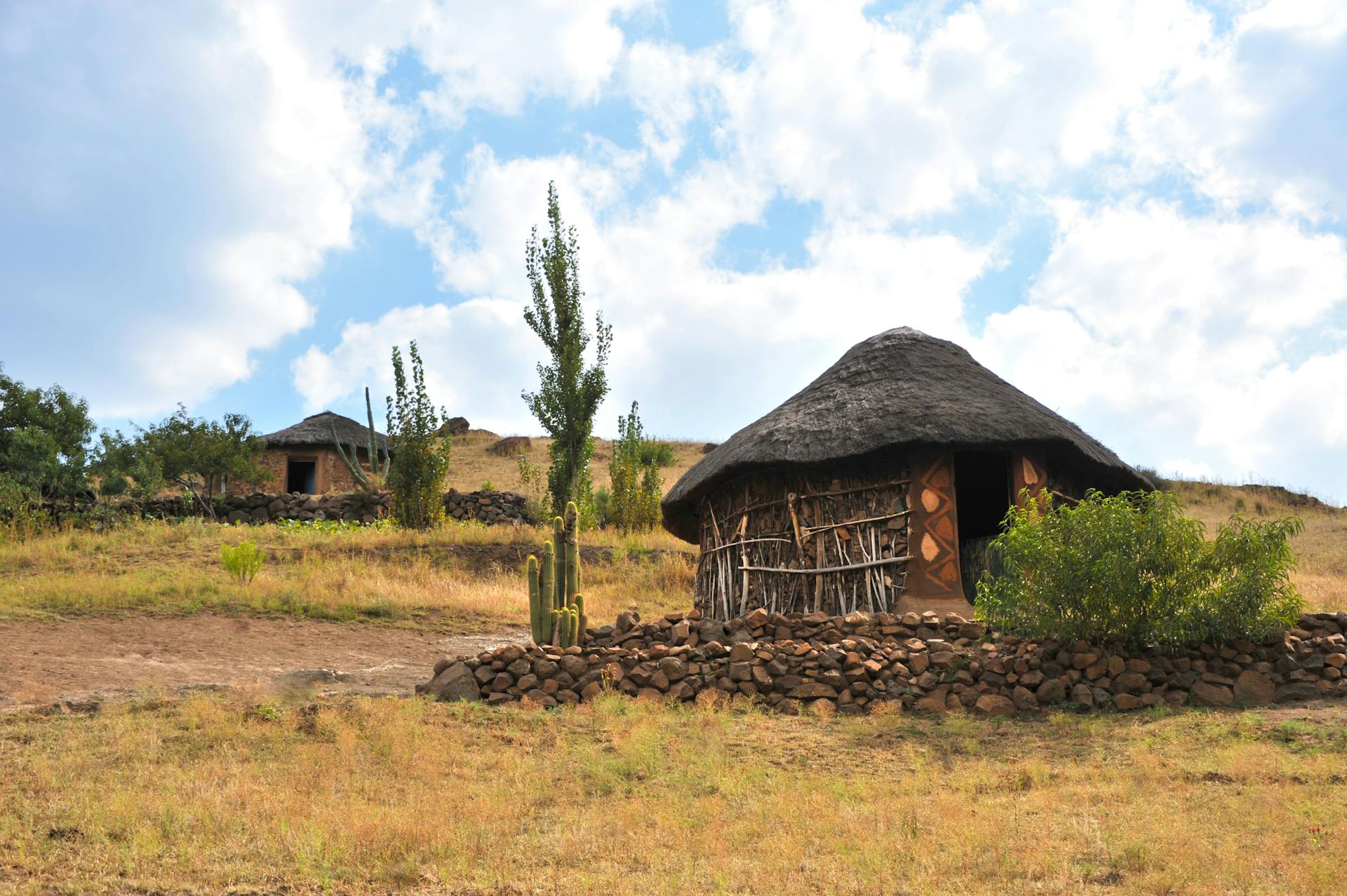 Traditional African thatched mud huts in a sandy Zambian village landscape