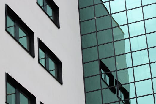 现代建筑立面的特写中，玻璃窗映出了城市环境