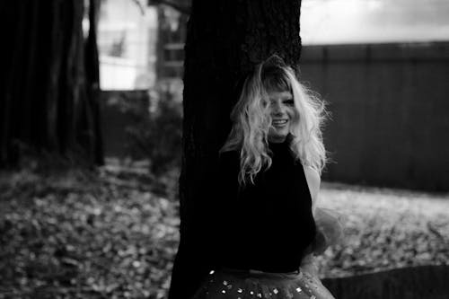 A woman in a skirt sitting on a tree